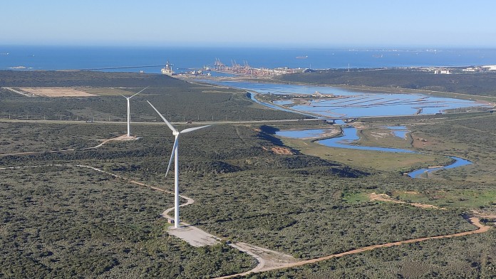 Förderung von grünem Wasserstoff in Südafrika. Eine Landschaft mit einem Wasserstoffterminal-Hafen und Windrädern im Vordergrund