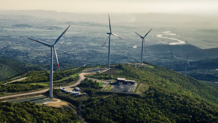 Luftaufnahme eines Windparks mit mehreren Windturbinen in einem Gebirge von Nordmazedonien
