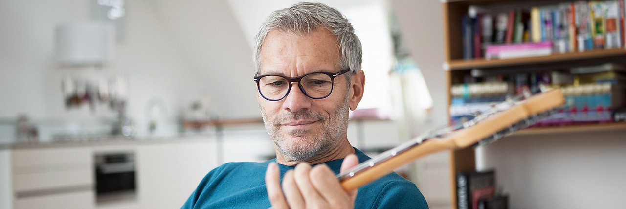 Ein Mann sitzt auf der Couch und spielt Gitarre