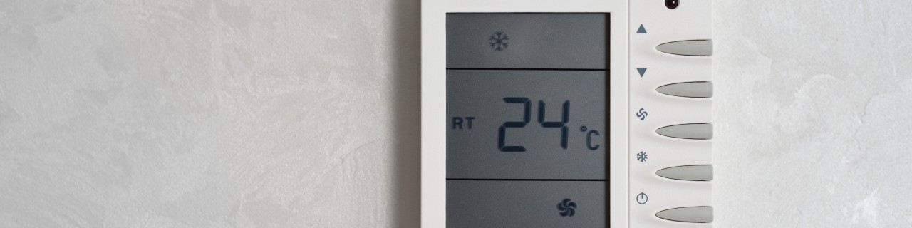 Temperaturregler mit Bildschirm hängt an der Wand und zeigt 24 Grad Celsius an.