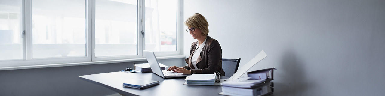 eine Frau sitzt und arbeitet am Schreibtisch