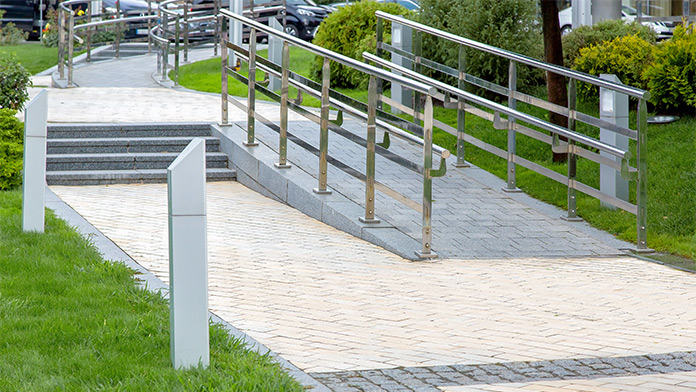 Stone ramp with iron railing in a city park for barrier-free mobility