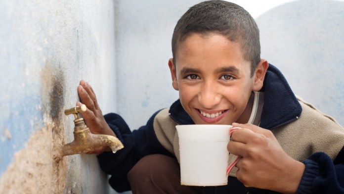 A boy drinks from a mug