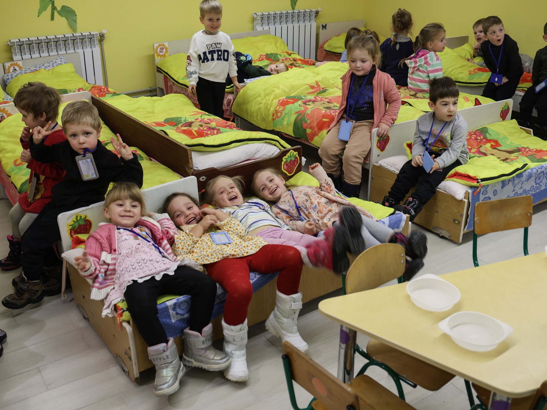 A group of children in a relaxation room with beds.