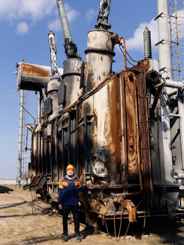 Olexandr Malyon, an employee of Ukrenergo, stands in front of a transformer station in the central region of the 
