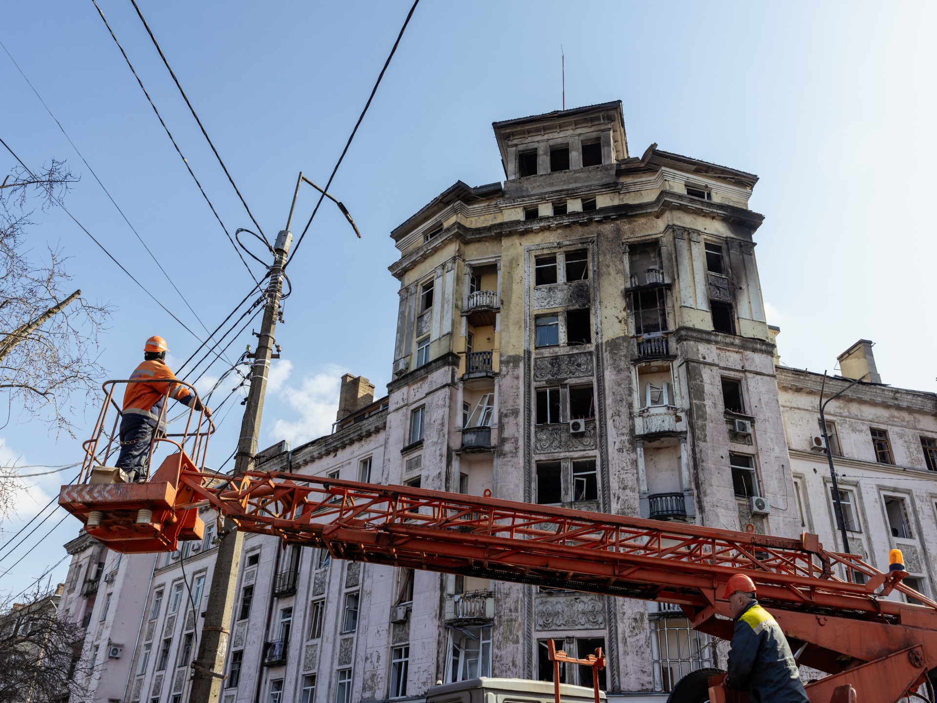 Anwohner der Stadt Kyiv räumen nach einem Angriff die Trümmer weg, Bauarbeiter reparieren Straßen und Stromleitungen. 