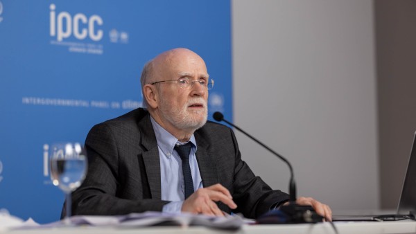 Mr Pörtner sitting at a table, speaking into a microphone