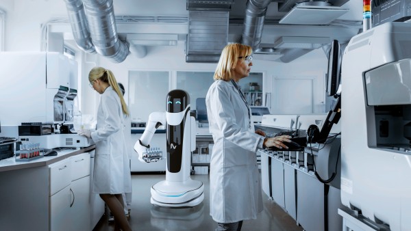 Two women an a robot in a lab